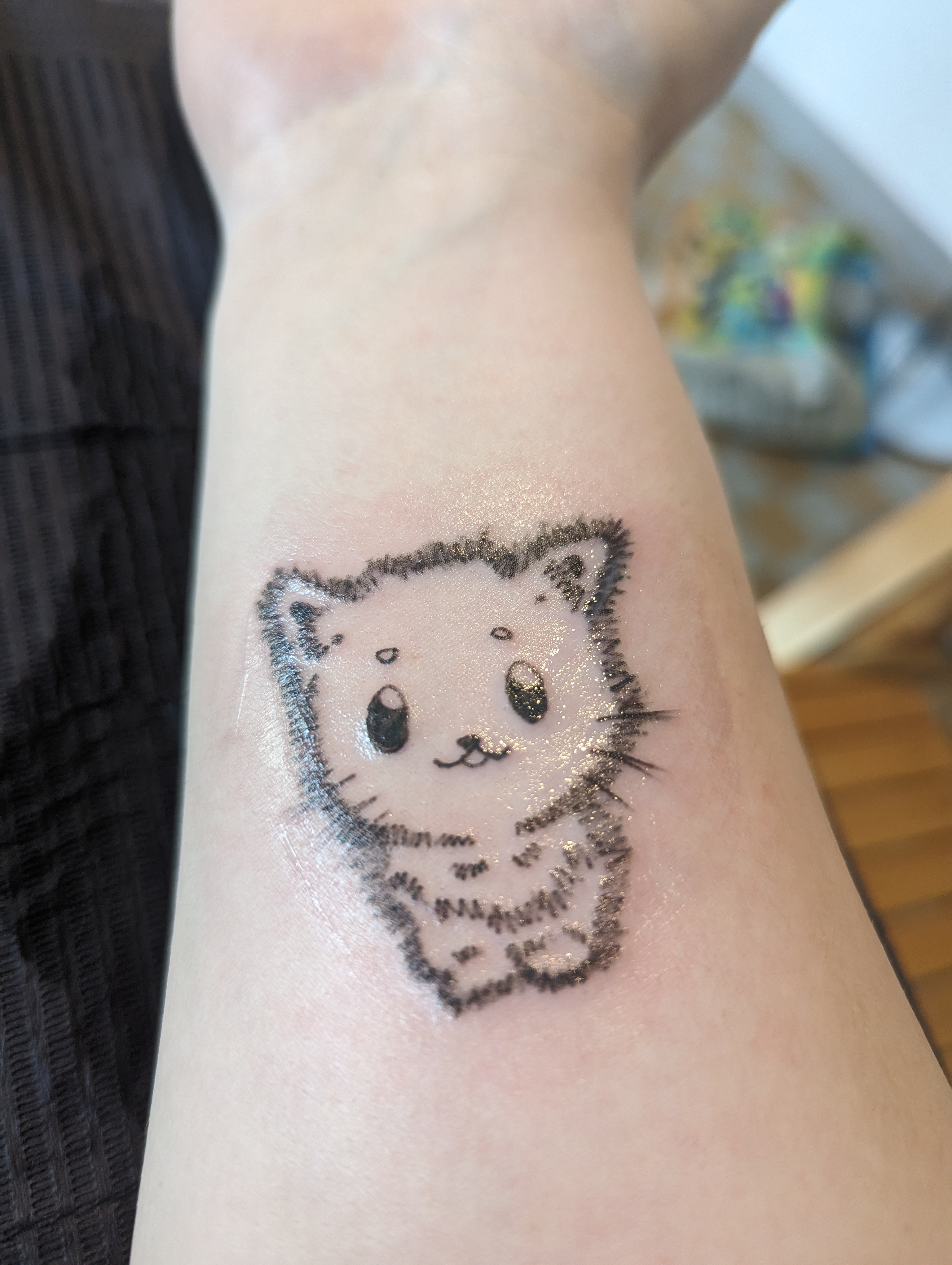 and a tattoo of the maia kitten design on the other
