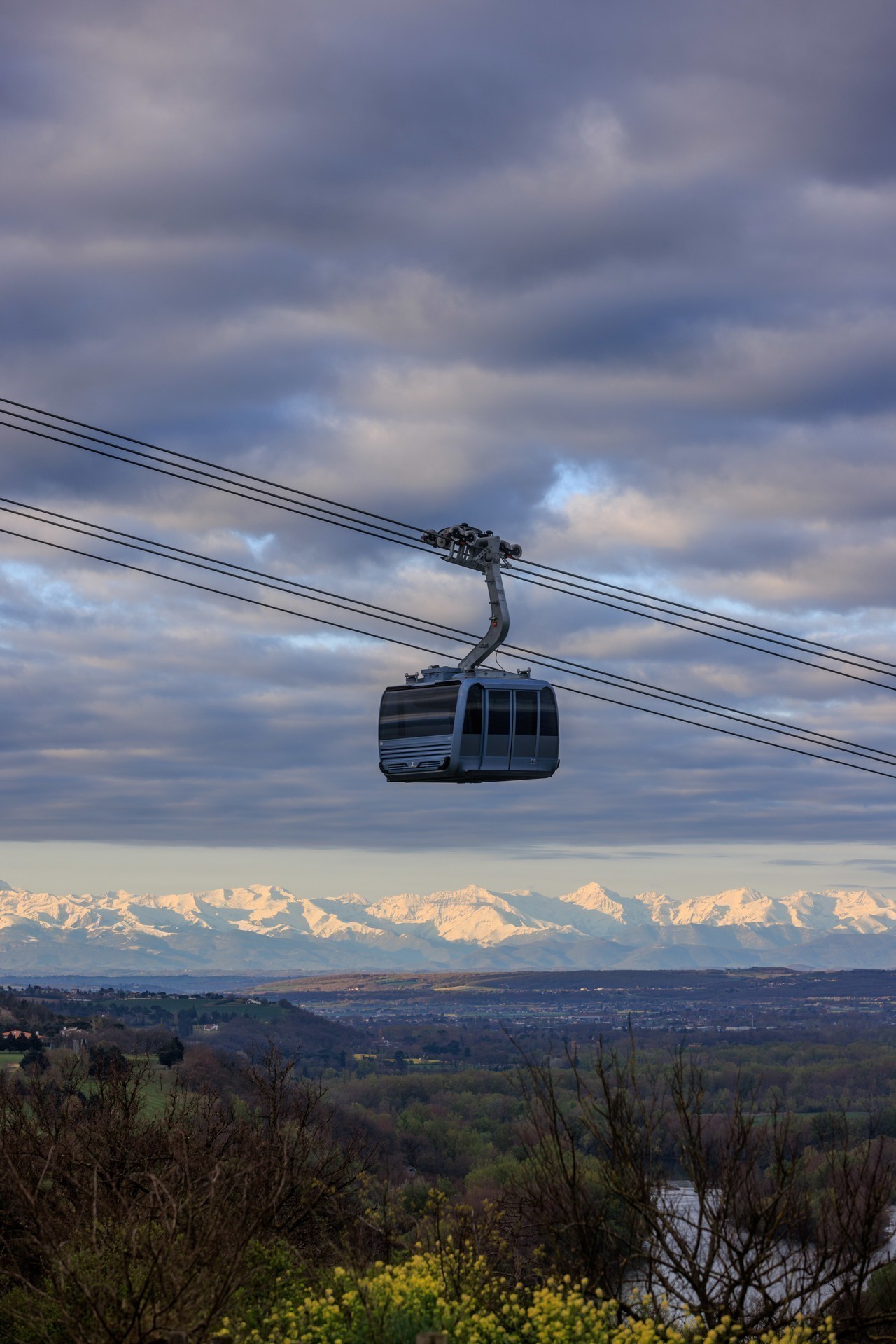 Picture of the cable car (téléphérique) in Toulouse. You can see mountains in the background of the image. The cabin is not shaped like the fuselage of a plane, alas.