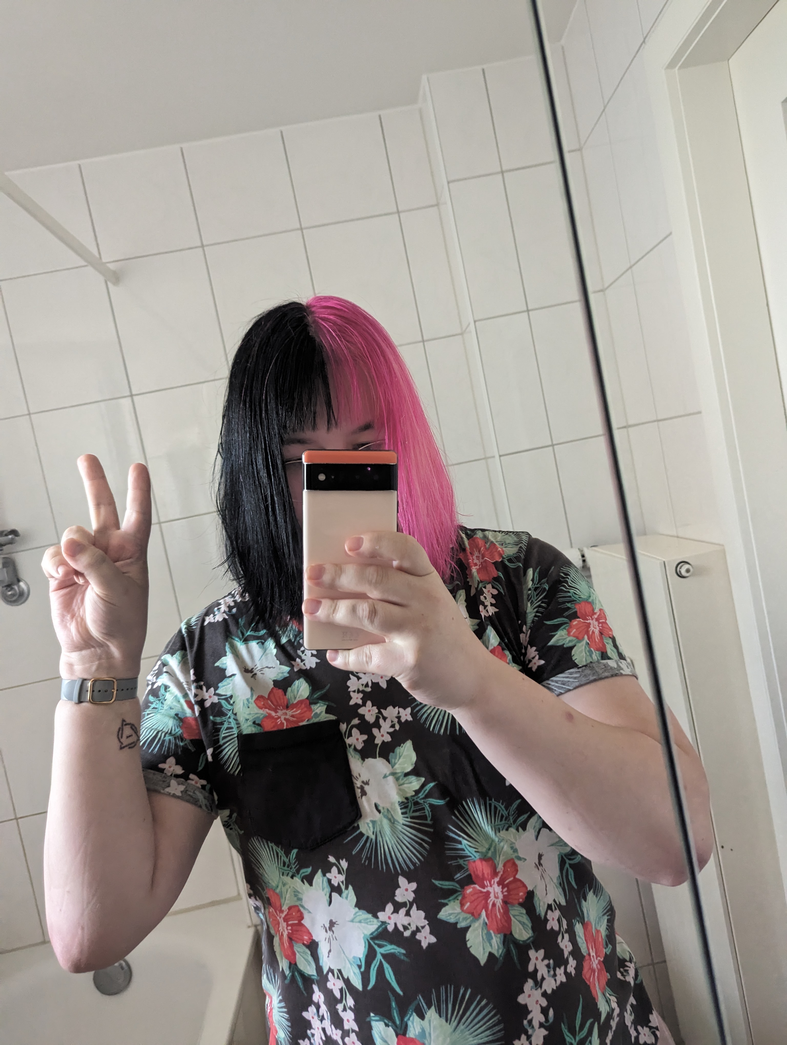 mirror selfie of maia with half black and half pink hair