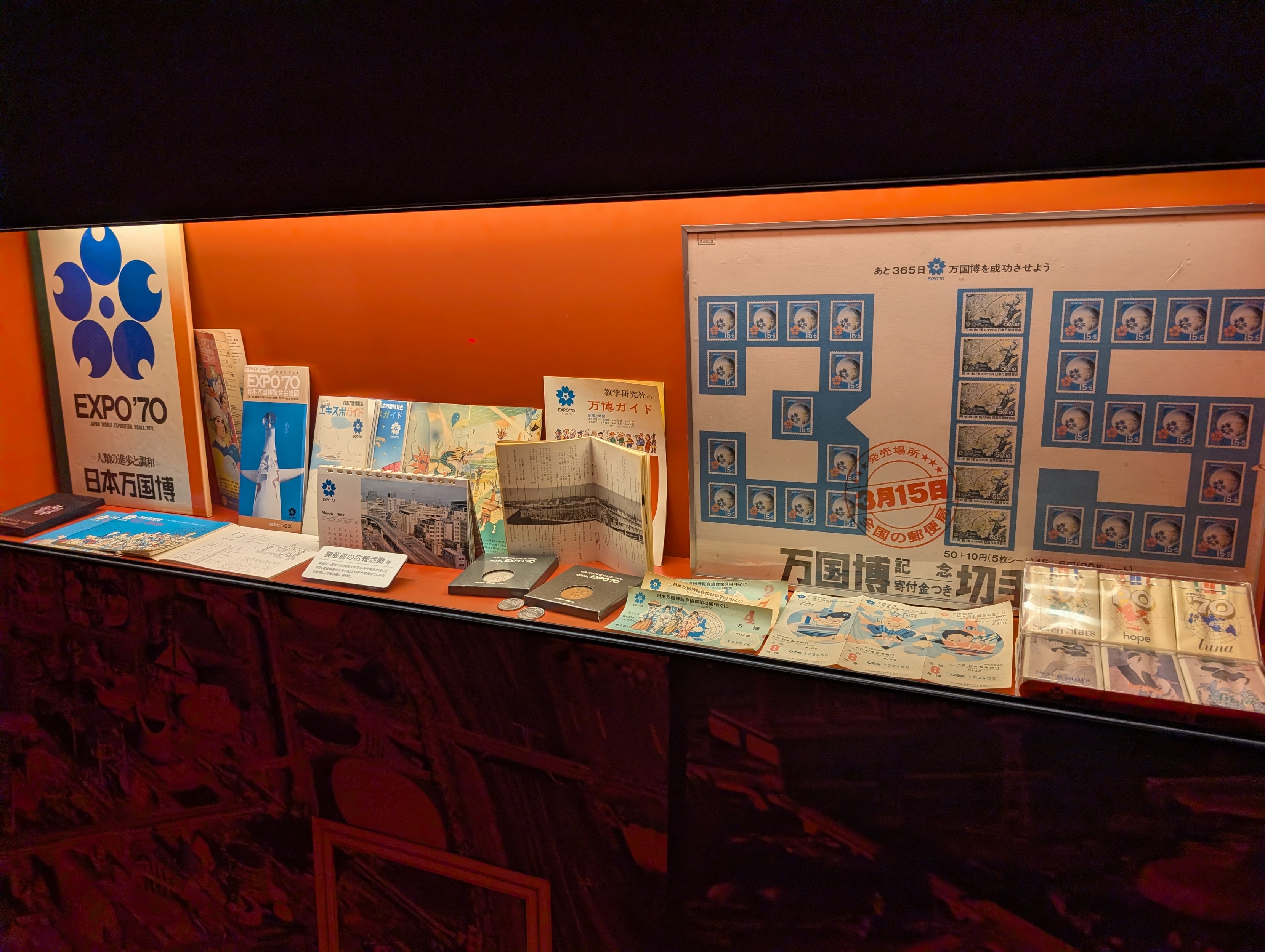 A selection of Expo 70 merch in a display case. It's a variety of things from notebooks, tickets pamphlets etc. 