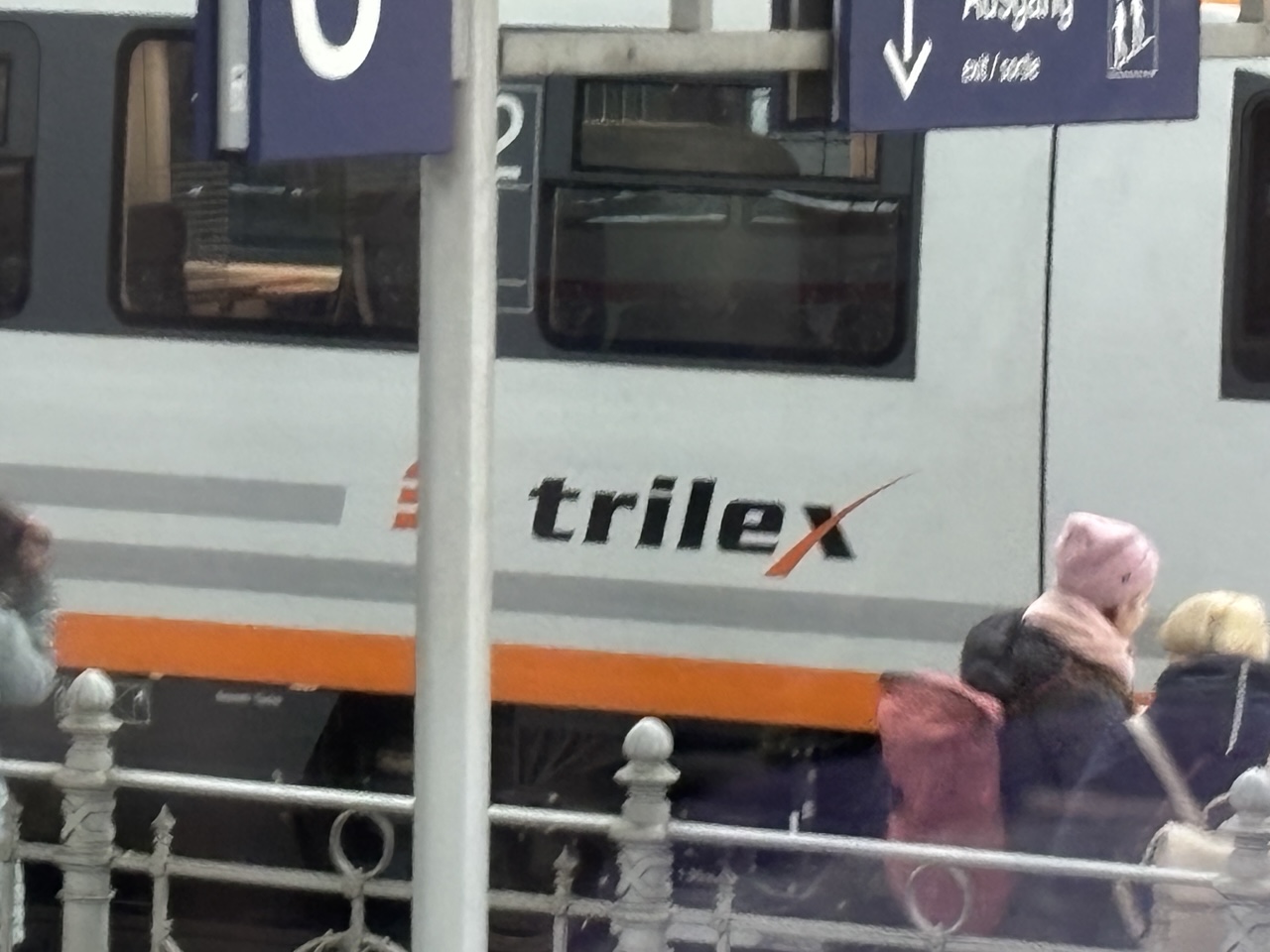 a train is waiting at a station, the photo is zoomed in to mostly show a logo that reads “trillex”