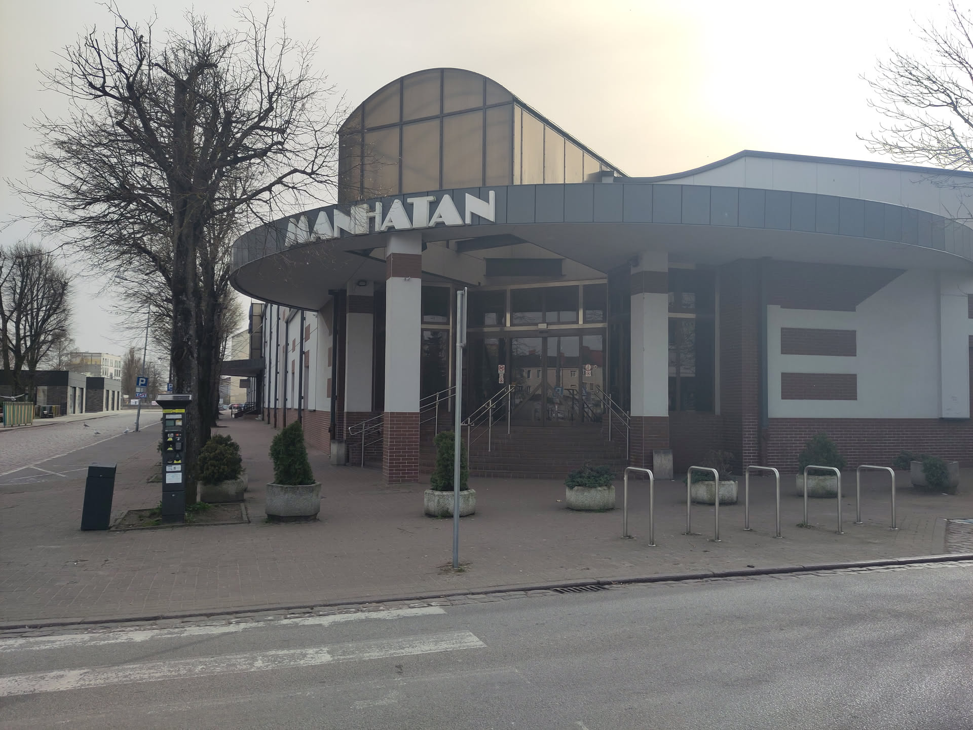A very 90s looking single story shopping mall with  a proud sign MANHATAN (yes, with one T) above the entrance)