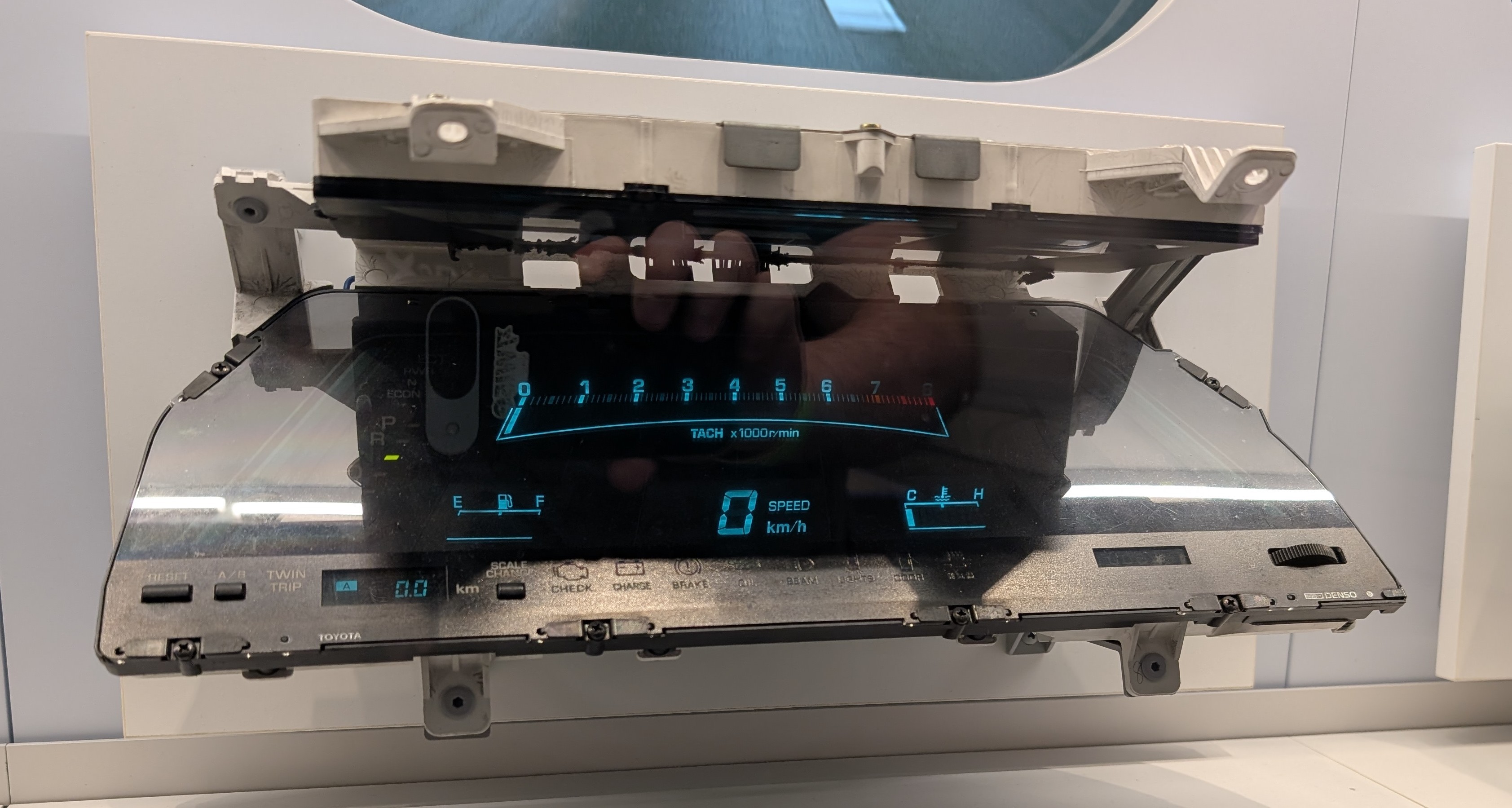 A digital instrument cluster from the 80s. It's illuminated in blue but isn't displaying any values. 