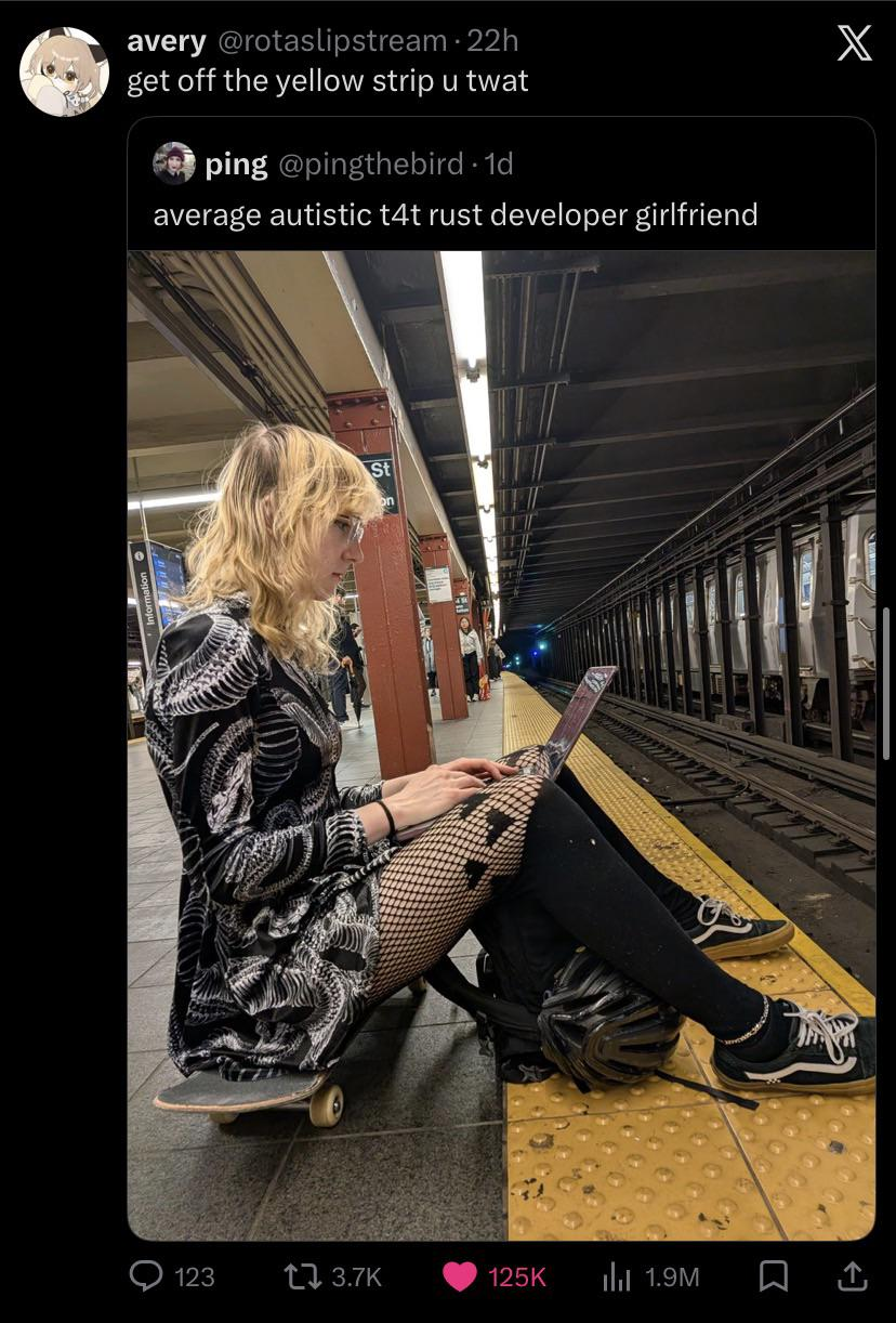 A screenshot of an X (Twitter) post by avery (@rotaslipstream) that reads, "get off the yellow strip u twat". It quotes a post by ping (@pingthebird) captioned, "average autistic t4t rust developer girlfriend". 

The included photo shows a person with shoulder-length blonde hair sitting on a skateboard on a subway platform, typing on a laptop. They are wearing a black-and-white patterned dress, fishnet stockings, and black Vans sneakers. They are sitting directly on the textured yellow safety strip at the very edge of the platform next to the subway tracks.