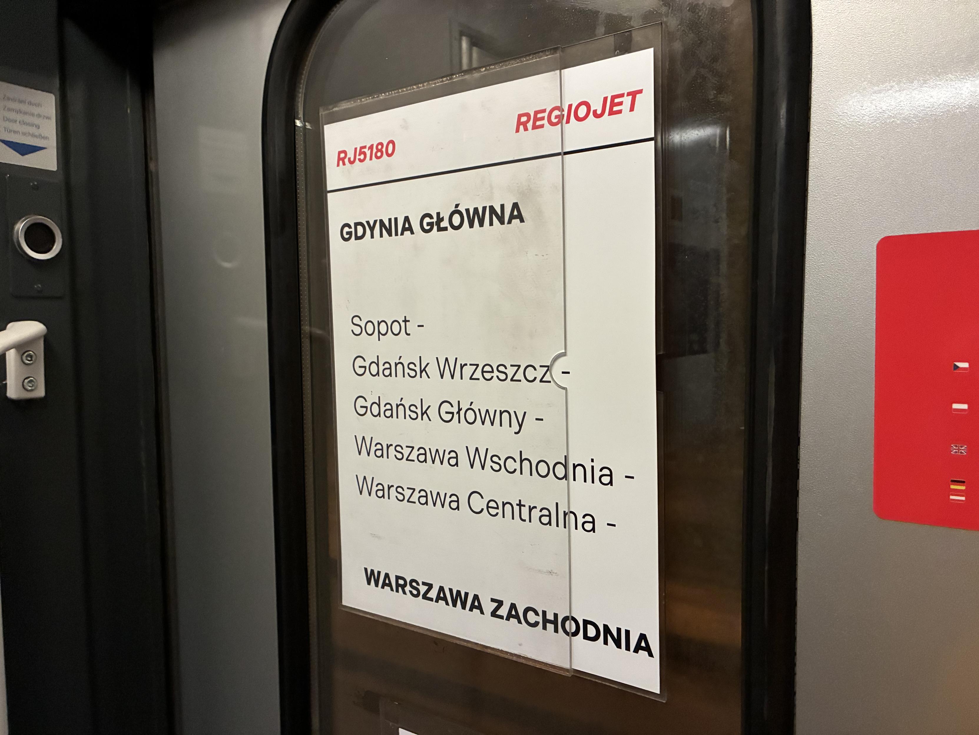 route information on a piece of paper, mounted on the inside of the train door. it’s a RegioJet train RJ 5180 from Gdynia Główna to Warszawa, going through Sopot and Gdańsk
