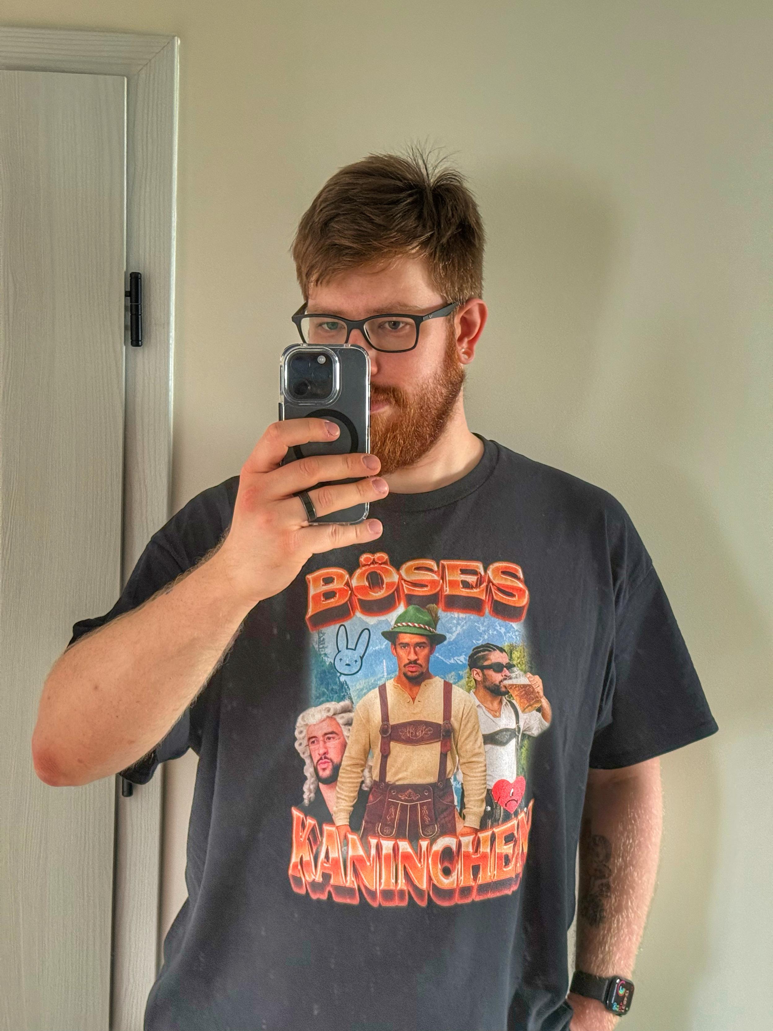 Selfie w lustrze, jestem ubrane w koszulkę „Böses Kaninchen” (Bad Bunny po niemiecku), na koszulce trzy zdjęcia Bad Bunny’ego w typowo niemieckich strojach