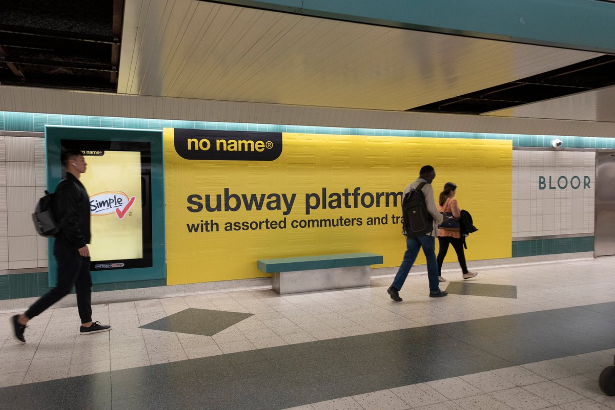 A station hallway with a huge ad of no name, the Canadian store chain, in the style their product labels: "subway platform, with assorted commuters and trains"