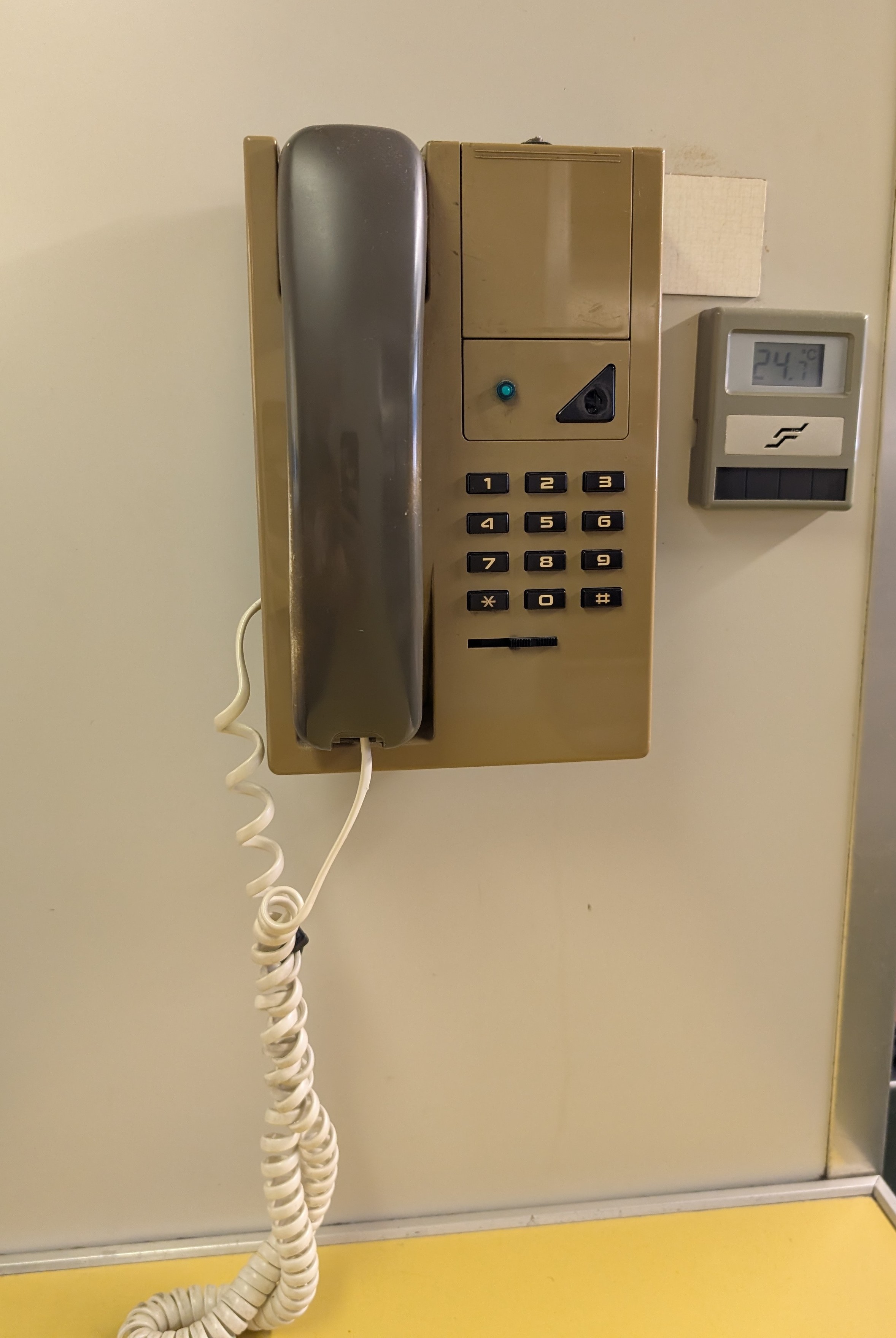 An old cordless phone attached to a partition wall